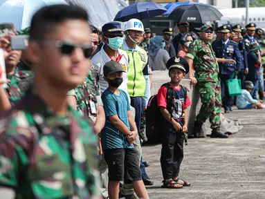 Warga menyaksikan atraksi udara saat gladi bersih memperingati hari ulang tahun (HUT) ke-77 di Lanud Halim Perdanakusuma, Jakarta, Kamis (6/4/2023). (Liputan6.com/Faizal Fanani)