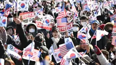 Para pendukung Presiden Korea Selatan yang dimakzulkan, Yoon Suk Yeol, melambaikan bendera Amerika Serikat dan Korea Selatan saat mereka berkumpul di dekat kediaman kepresidenan di Seoul pada tanggal 31 Desember 2024. (JUNG YEON-JE/AFP)