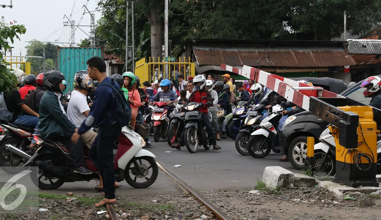 Pemotor menerobos palang pintu perlintasan kereta di kawasan Kemayoran, Jakarta, Kamis (6/10). Perilaku pengguna jalan yang tidak tertib seperti ini berisiko menimbulkan kecelakaan lalu lintas. (Liputan6.com/Immanuel Antonius)