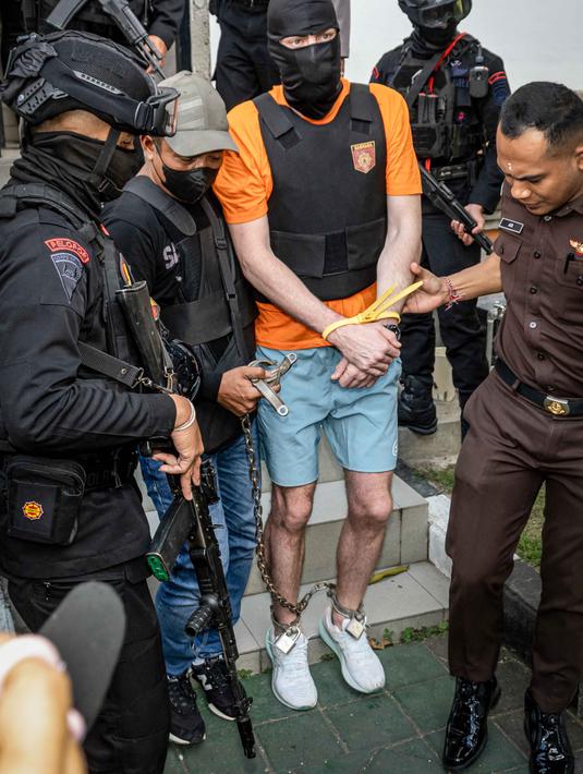 Sebelumnya, polisi menangkap ketiga tersangka yang merupakan warga negara Australia terkait kasus penembakan di sebuah vila di Munggu, Badung, Bali, pada 14 Juni 2025. Tampak dalam foto, tersangka Darcy Francesco Jenson (tengah) dibawa kembali ke rumah tahanan setelah menjalani pemeriksaan oleh pihak kejaksaan di Badung, Bali, pada 15 Oktober 2025. (Dicky Bisinglasi/AFP)