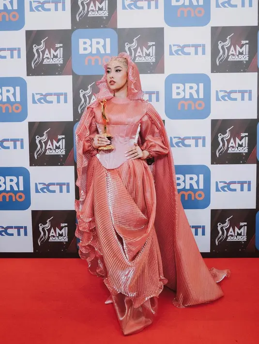 Menang award, Jinan tampil mencolok dengan pleated dress dan korset pink. Dipadukan dengan hijab ruffle bergaya Arabian.  [@jinanlaetitia]