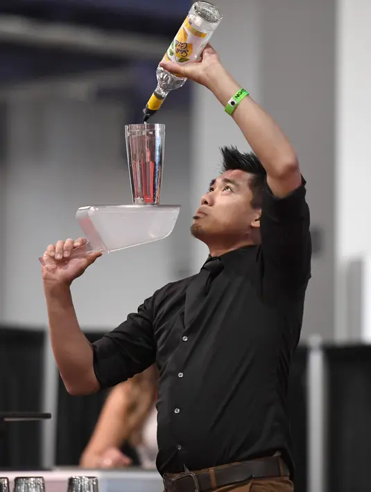 Bartender Ram Ong menyajikan minuman saat berkompetisi dalam Shake It Up Flair Competition pada hari kedua dari Nightclub & Bar Convention and Trade Show tahunan ke-34 di Las Vegas, Nevada (26/3). (AFP Photo/Ethan Miller)