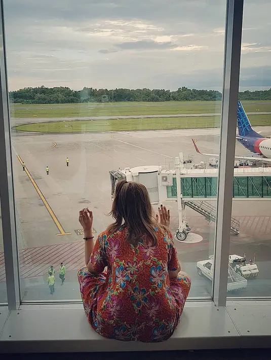 DJ Butterfly memang senang tampil apa adanya. Lihat saja, ia terlihat santai duduk di dekat jendela saat di bandara. (Foto: instagram.com/dj_kattybutterfly36)