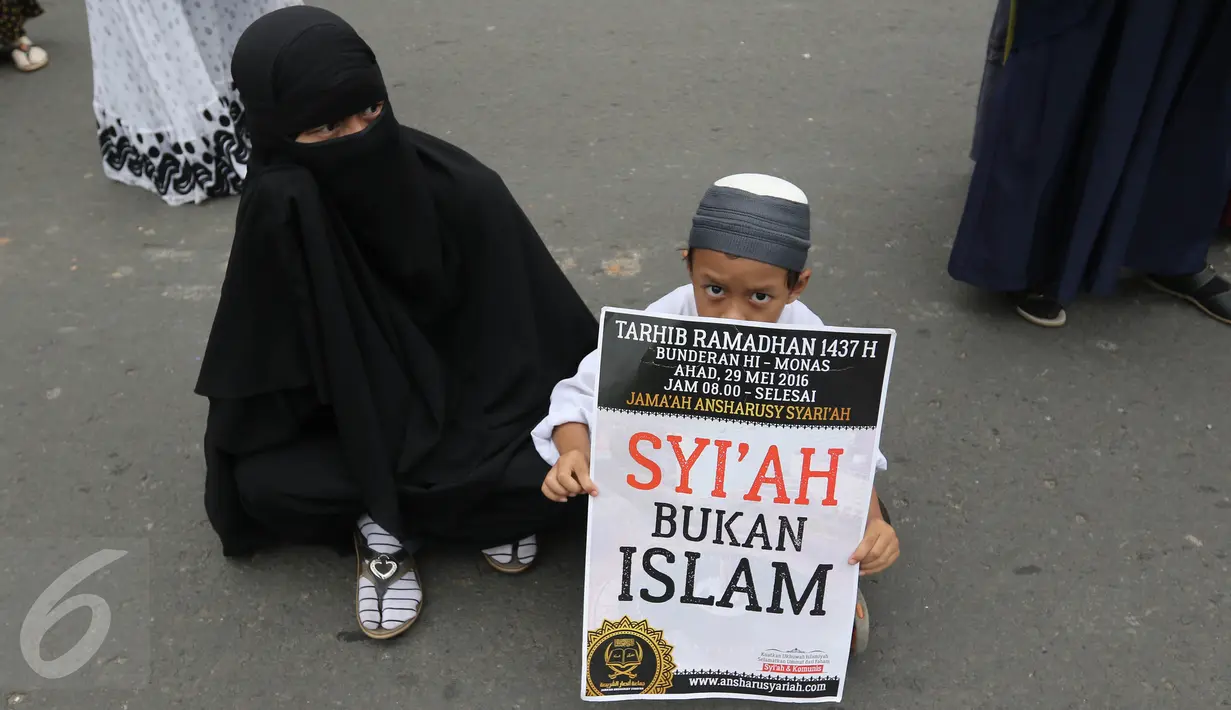 Seorang anak memegang poster saat mengikuti aksi Tarhib Ramadhan di Bundaran HI, Jakarta Pusat, Minggu (29/5). Aksi tersebut selain Tarhib Ramadhan mereka juga menolak ajaran syi'ah, Komunis dan kaum LGBT. (Liputan6.com/Herma Zakharia)