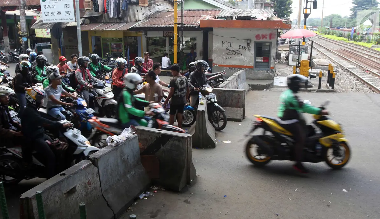 Pengendara motor melintas di perlintasan kereta api di kawasan Roxy, Jakarta, Rabu (21/3). Petugas Sudinhub Jakpus telah menutup akses perlintasan KA di depan Roxy 20 September 2017, namun mendapat protes keras dari warga.  (Liputan6.com/Arya Manggala)