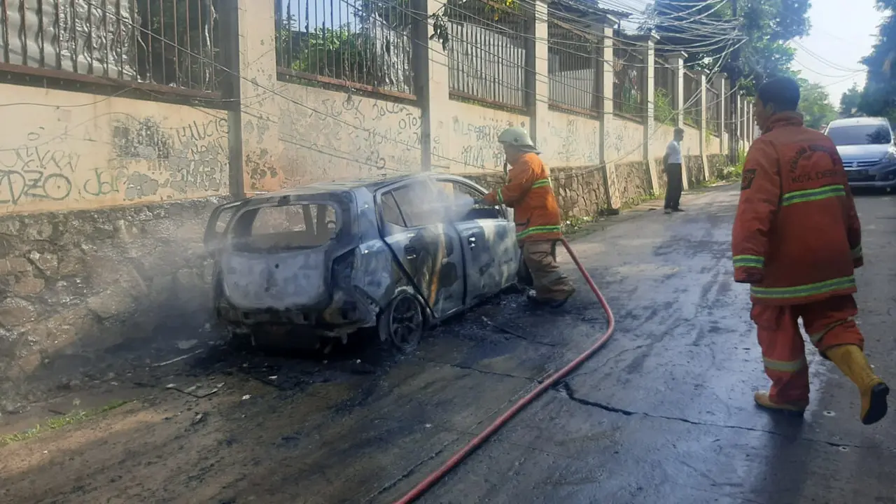 Sebuah mobil jenis Daihatsu Ayla tiba-tiba kebakaran saat melintas dari arah Limo menuju Tugu Tanah Baru
