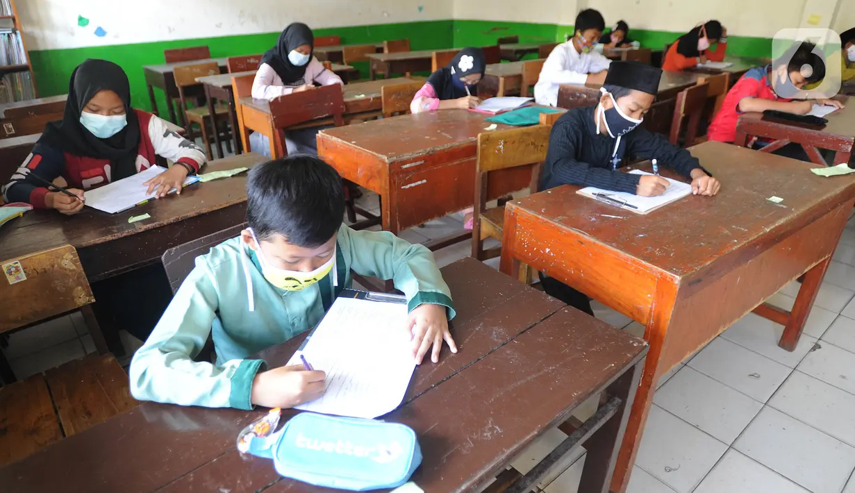Murid kelas V mengikuti ujian Penilaian Akhir Semester (PAS) tahun pelajaran 2020/2021 di Madrasah Ibtidayah (MI) Assu'ada di Pancoran Mas, Depok, Jawa Barat, Selasa (1/12/2020). Ujian dilaksanakan dengan menerapkan protokol kesehatan dalam kelas. (merdeka.com/Arie Basuki)