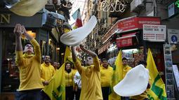 Anggota Pizzaioli Acrobats Coldiretti menunjukkan Pizzaioli untuk merayakan keputusan UNESCO di Naples, Italia, 7 Desember 2017. Pizzaioli adalah seni memutar adonan piza hingga mengembang dengan sempurna saat dipanggang. (Tiziana FABI/AFP)