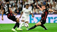 Pemain depan Real Madrid Rodrygo (tengah) berebut bola dengan pemain Red Bull Leipzig Abdou Diallo dan Willi Orban pada matchday 2 Liga Champions berlangsung di Santiago Bernabeu, Kamis (15/9/2022) dini hari WIB. Real Madrid menang susah payah 2-0 kala menjamu RB Leipzig. (Photo by JAVIER SORIANO / AFP)