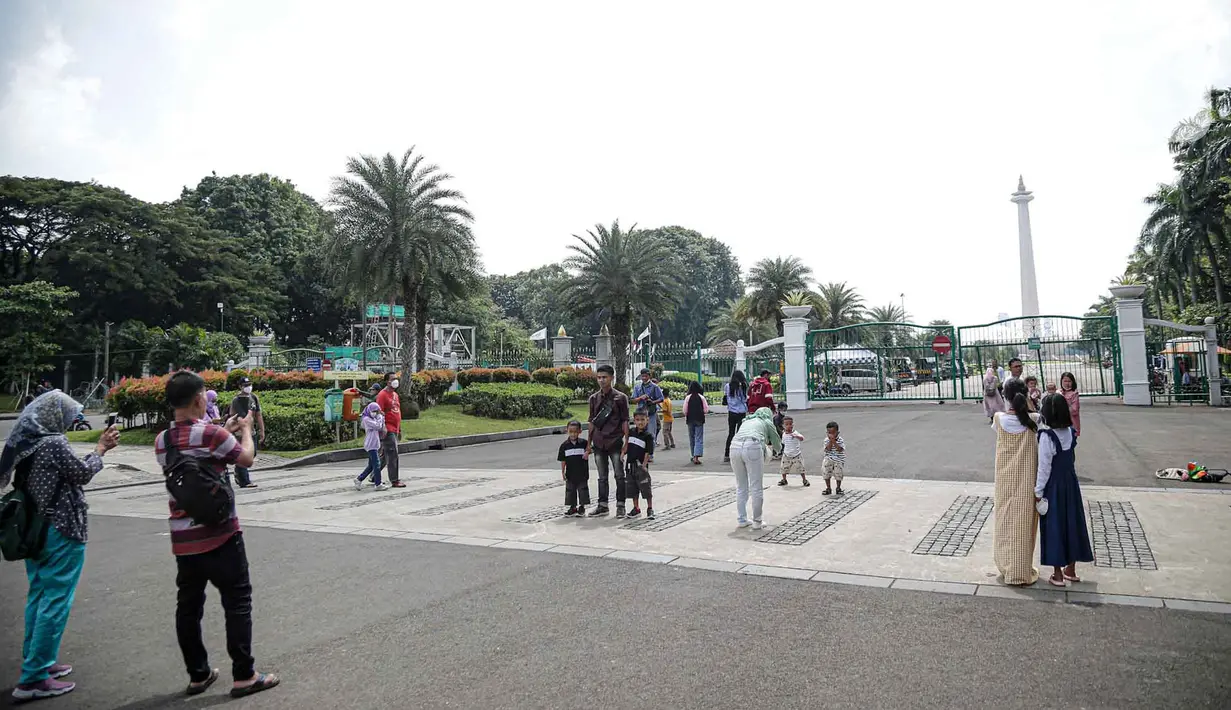 <p>Warga berfoto di halaman luar Monumen Nasional (Monas) Jakarta, Kamis (5/5/2022). Meski kawasan Monas masih ditutup sejak awal pandemi COVID-19 pada Maret 2020 lalu namun tidak menyurutkan minat warga untuk bisa berwisata yaitu dengan memanfaatkan kawasan luar monumen tersebut. (Liputan6.com/Faizal Fanani)</p>