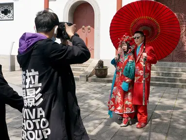 Sepasang calon pengantin berpose dalam sesi foto pranikah di Paviliun Qingchuan, Wuhan, Provinsi Hubei, China tengah, pada 12 April 2020. Warga Wuhan kembali melakukan persiapan pernikahan setelah meredanya pandemi corona Covid-19. (Xinhua/Wang Yuguo)