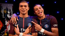 Striker PSG, Kylian Mbappe, berpose dengan patung lilinnya di Museum Grevin, Paris, Kamis (17/5/2018). Patung ini merupakan apresiasi karena keberhasilannya meraih gelar pemain muda terbaik dan trofi Liga Prancis. (AFP/Christophe Simon)