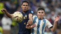 Pemain Timnas Prancis, Raphael Varane (kiri) berebut bola dengan pemain Timnas Argentina, Julian Alvarez dalam laga final Piala Dunia 2022 di Lusail Stadium, Lusail, Qatar, Minggu (18/12/2022) malam WIB. (AP Photo/Frank Augstein)