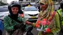 Pengendara sepeda motor saat mendapatkan bunga dari seorang mahasiswi dalam memperingati Hari Ibu,  Jakarta,Minggu (22/12/2014) (Liputan6.com/Johan Tallo)