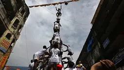 Pemuda India membentuk piramida manusia untuk memecahkan pot berisikan semacam susu dalam perayaan Festival Janmashtami di Mumbai, Senin (3/9). Festival Janmashtami dilakukan untuk menyambut kelahiran Dewa Krishna. (AP/Rafiq Maqbool)