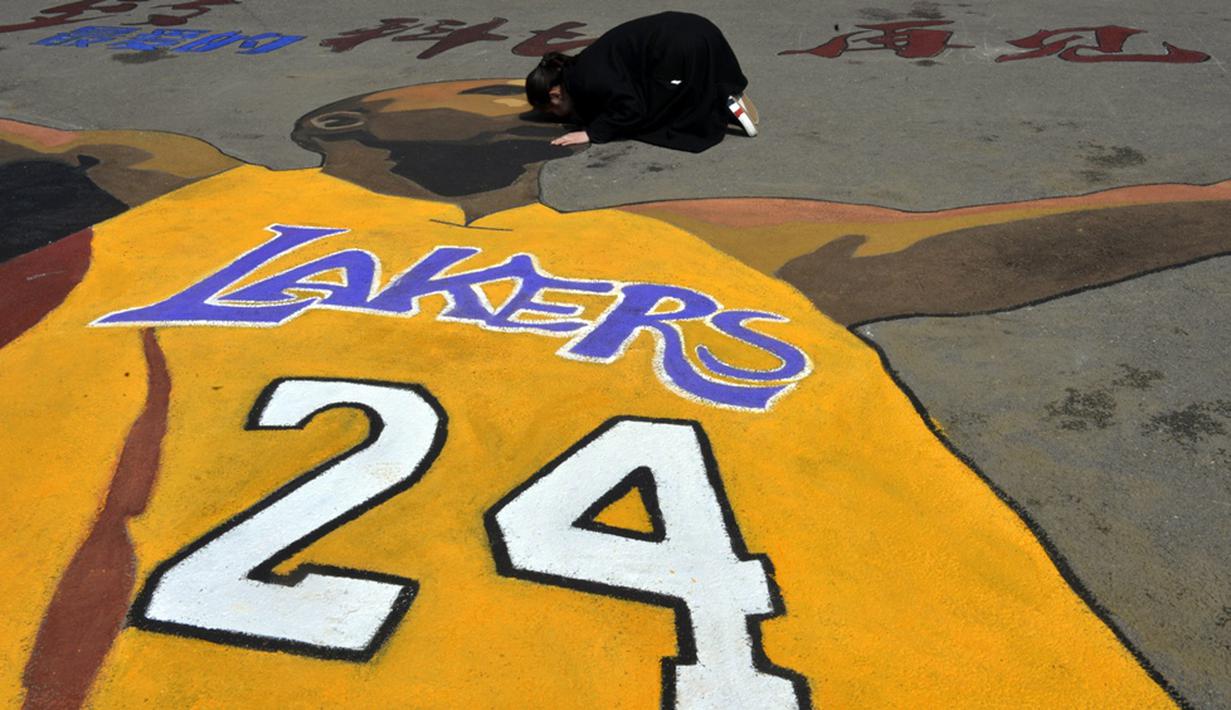 Seorang mahasiswi mencium gambar Kobe Bryant di Shenyang Sport University, Shenyang, China, (14/4/2016), untuk menghormati Kobe Bryant yang pensiun setelah 20 tahun bermain di NBA. (AFP)