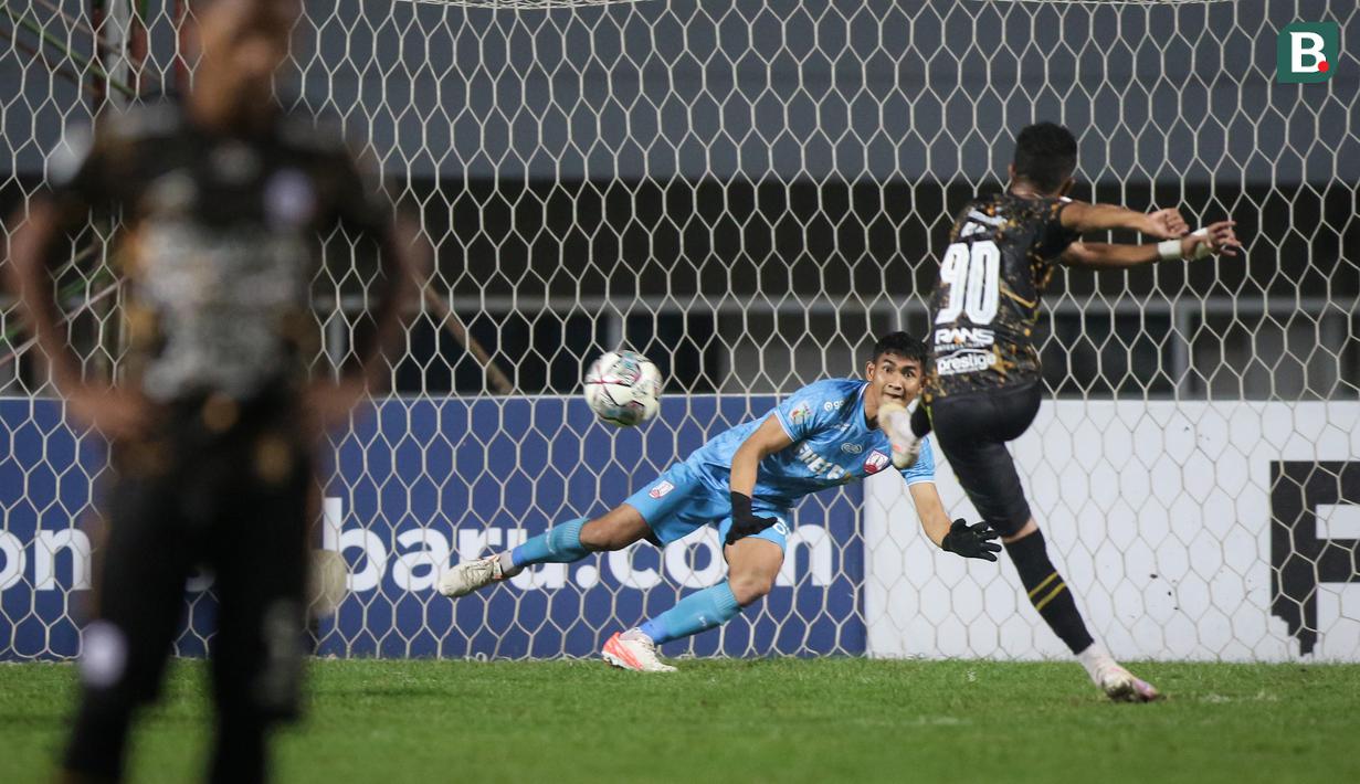 Kiper Persis Solo, Harlan Suardi gagal membendung eksekusi penalti pemain Rans Cilegon FC, Alfin Tuasalamony yang mengubah skor menjadi 1-2 dalam laga final Liga 2 2021 di Stadion Pakansari, Bogor, Kamis (30/12/2021). (Bola.com/Bagaskara Lazuardi)
