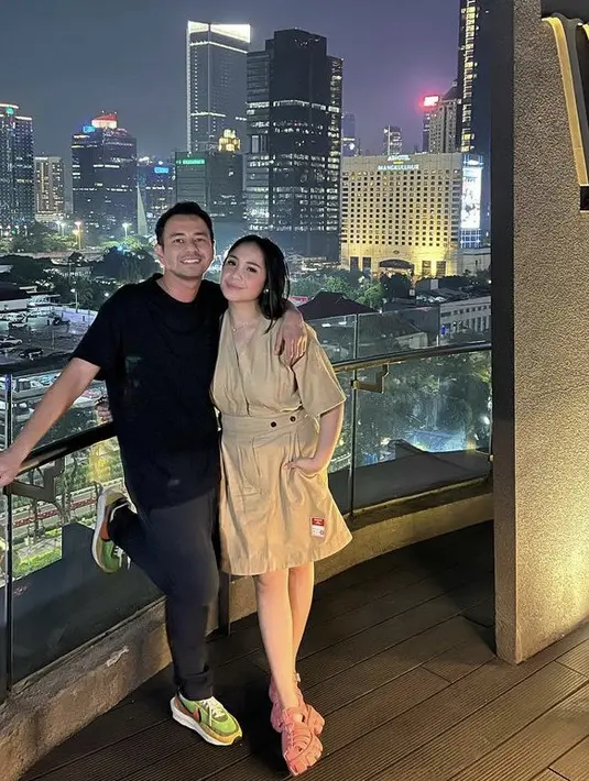 Nagita memadukan dress cokelat tersebut dengan sandal sepatu warna pink. Rambut Nagita pun dibiarkan terurai, serta menggunakan makeup flawlessnya. Credit: Instagram (@rieta_amilia)