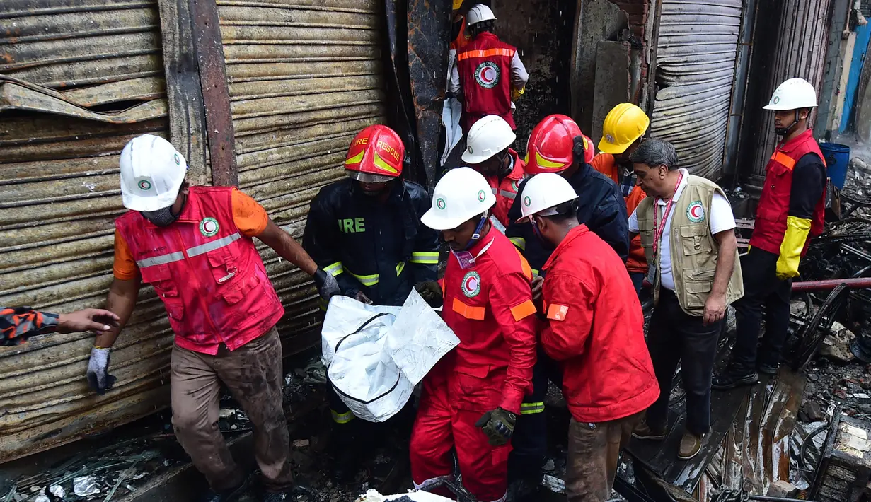 Petugas penyelamat membawa jenazah korban setelah kebakaran di gedung apartemen di Dhaka (21/2). Setidaknya 69 orang tewas dalam kebakaran besar yang melanda gedung  yang juga digunakan sebagai gudang bahan kimia. (AFP Photo/Munir Uz Zaman)