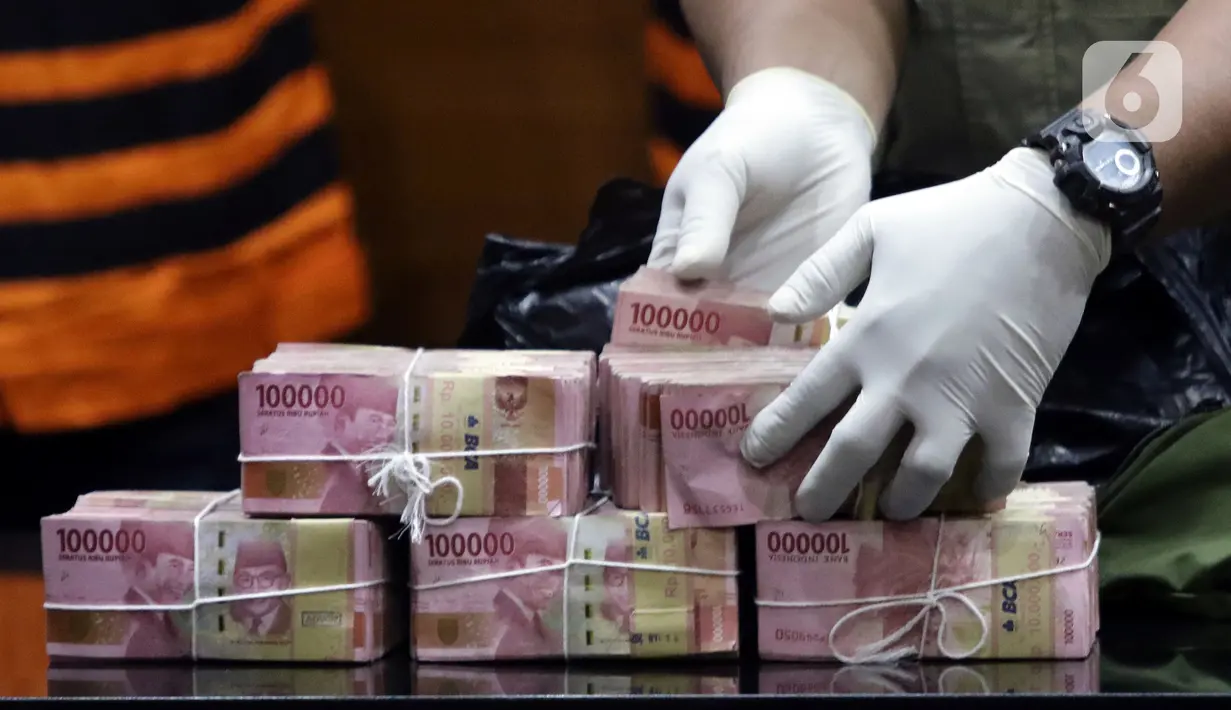 Petugas menunjukkan barang bukti hasil OTT Bupati Langkat, Terbit Rencana Perangin Angin saat rilis penahanan tersangka di Gedung KPK, Jakarta, Kamis (20/1/2022). KPK resmi menahan Bupati Langkat, Terbit Rencana Perangin Angin dan menyita uang sebesar Rp 786 juta. (Liputan6.com/Helmi Fithriansyah)