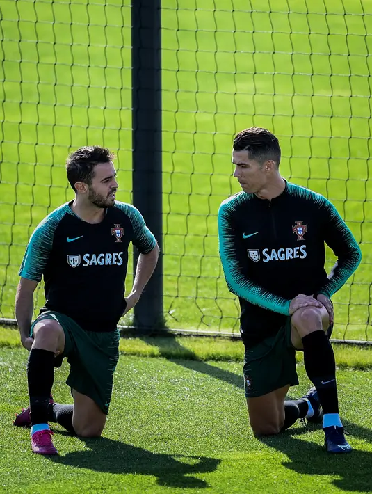 Penyerang Portugal Cristiano Ronaldo (kanan) berbincang dengan Bernardo Silva saat latihan bersama jelang menghadapi Luksemburg pada laga kualifikasi Euro 2020 di Oeiras, Portugal, Rabu (9/10/2019). Portugal akan menghadapi Luksemburg pada 12 Oktober 2019. (Patricia De Melo Moreira/AFP)