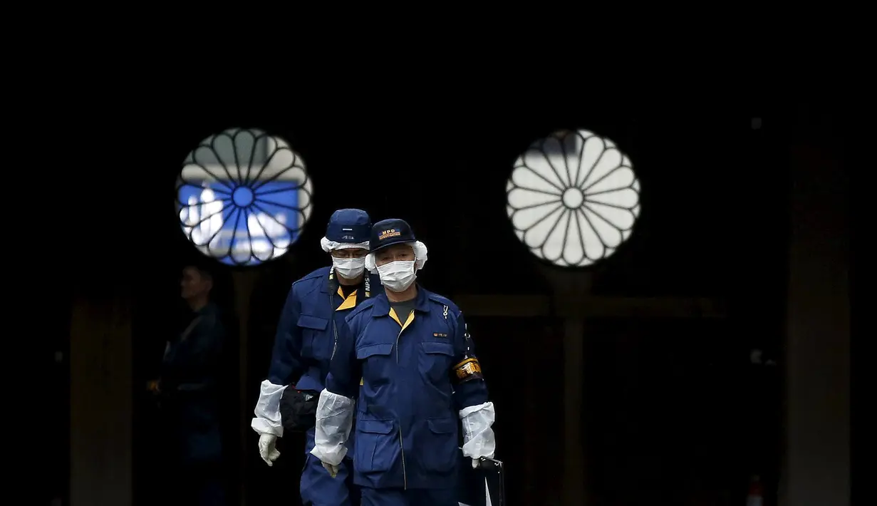 Petugas Polisi saat memeriksa tempat meledaknya sebuah bom di kuil Yasukuni di Tokyo, Jepang, (23/11). Ledakan bom terdengar jelas di kamar mandi umum Kuil Yasukuni yang membuat sebagian ruangan rusak. (REUTERS/Toru Hanai)