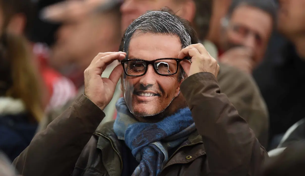 Suporter menggunakan topeng pelatih Chelsea Jose Mourinho pada laga Liga Premier Inggris di Stadion Britania, Minggu (8/11/2015) dini hari WIB. Mourinho dilarang mendampingi timnya oleh Football Association ( FA ). (AFP Photo/Paul Ellis)