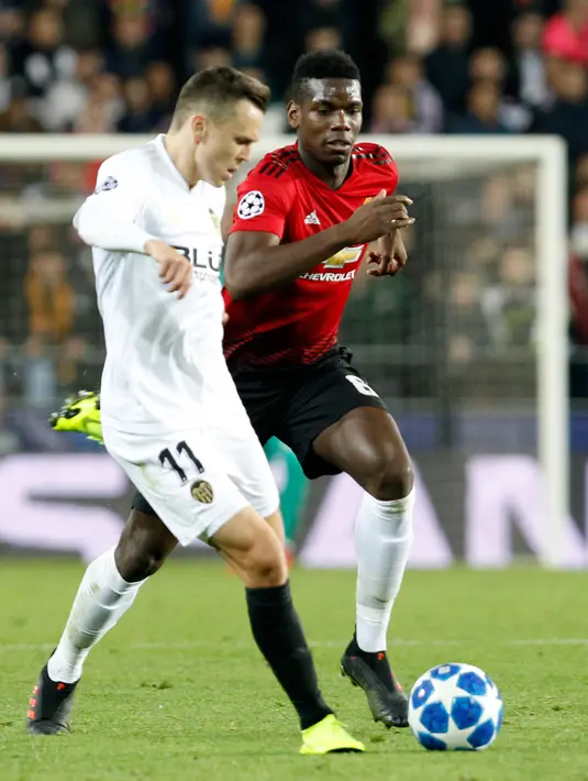 Pemain Manchester United (MU), Paul Pogba (kanan) berduel dengan Denis Cheryshev saat bertanding melawan Valencia pada babak penyisihan Grup H Liga Champions di Stadion Mestalla, Valencia, Spanyol, Rabu (12/12). (AP Photo/Alberto Saiz)