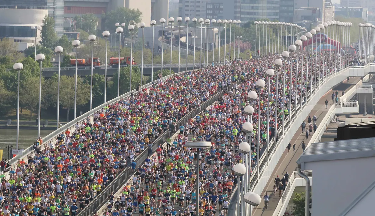 Ribuan atlet melintasi jembatan yang berada di atas sungai Danube sesaat setelah dimulainya Vienna City Marathon 2018 di Wina, Austria, Minggu (22/4). Acara lari maraton ini diikuti  peserta dari berbagai negara. (AP Photo /Ronald Zak)