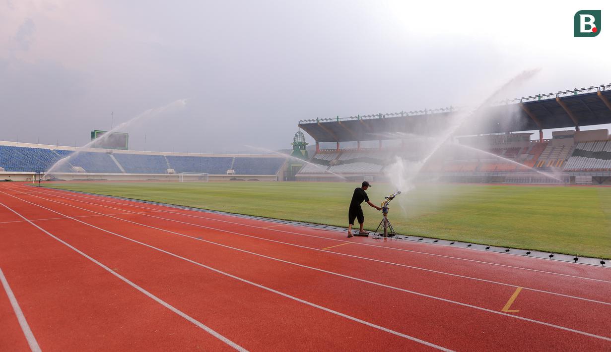 <p>Seorang pekerja menyiram rumput Stadion Si Jalak Harupat (SJH), Bandung, Sabtu (21/10/2023). (Bola.com/Bagaskara Lazuardi)</p>