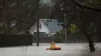 Warga menggunakan perahu kecil melintasi banjir di Christchurch, Selandia Baru, Sabtu, (22/7). Dewan Kota Christchurch mengatakan keadaan darurat setelah Sungai Heathcote meluap akibat cuaca yan buruk. (AP Photo / Mark Baker)
