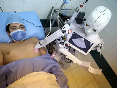 Robot Cira 03 melakukan pemeriksaan ekokardiogram terhadap seorang sukarelawan di sebuah rumah sakit di Kota Tanta, Provinsi Gharbiya, Mesir, 3 Desember 2020. Sebuah robot putih berbentuk manusia berjalan di koridor bangsal darurat sebuah rumah sakit swasta di Kota Tanta. (Xinhua/Ahmed Gomaa)