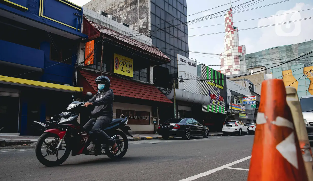 Pengendara motor melintas di depan pertokoan yang tutup di kawasan little Tokyo, Blok M, Jakarta, Rabu (21/7/2021). Pemerintah resmi menetapkan pemberlakuan pembatasan kegiatan masyarakat (PPKM) level 4 hingga 25 Juli mendatang untuk mencegah penyebaran virus Covid-19. (Liputan6.comn/Faizal Fanani)