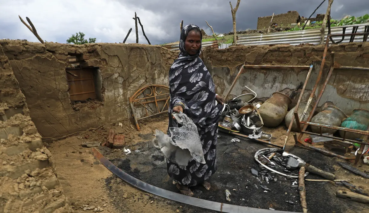 Seorang wanita berdiri di dalam rumahnya yang rusak setelah bentrokan etnis di negara bagian Nil Biru Sudan, di kota Roseires, Sudan tenggara (8/8/2022). Bentrokan etnis dalam sengketa tanah yang mematikan di negara bagian Nil Biru Sudan telah menewaskan 105 orang dan melukai 291, kata menteri kesehatan negara bagian itu. (AFP/Ashraf Shazly)