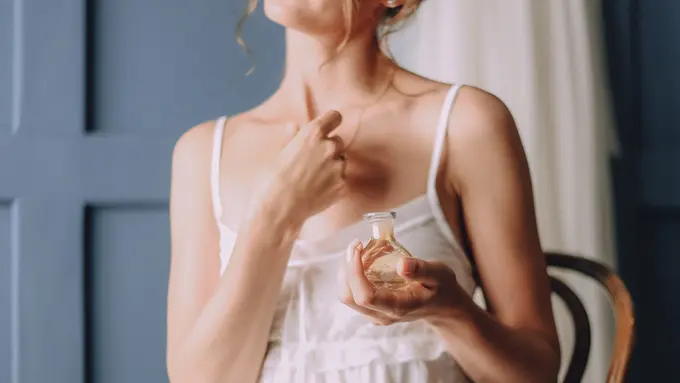 Seorang perempuan sedang mengaplikasikan parfum di area tubuhnya (Foto Dok: Freepik/freepic.diller)