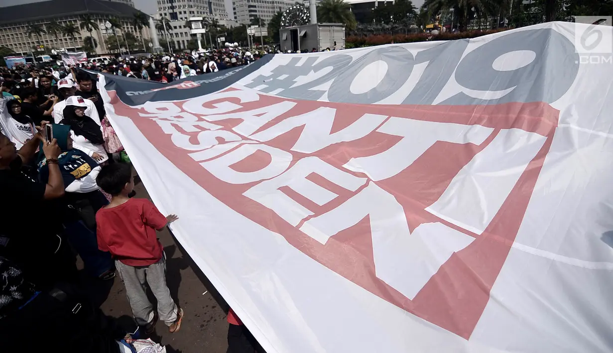 Massa mengibarkan bendera raksasa bertuliskan '#2019GantiPresiden' saat deklarasi akbar di Monas, Jakarta, Minggu (6/5). Massa menyerukan pergantian presiden secara konstitusional melalui Pilpres 2019. (Merdeka.com/Iqbal Nugroho)
