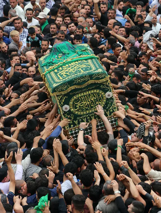 Umat Syiah Irak membawa peti jenazah saat memperingati wafatnya Imam Musa al-Kadhim di Kadhimiya, distrik utara Baghdad, Irak (23/4). Imam Musa al-Kadhim adalah imam ketujuh dari 12 imam Syiah yang meninggal pada 799. (AFP/Sabar Arar)