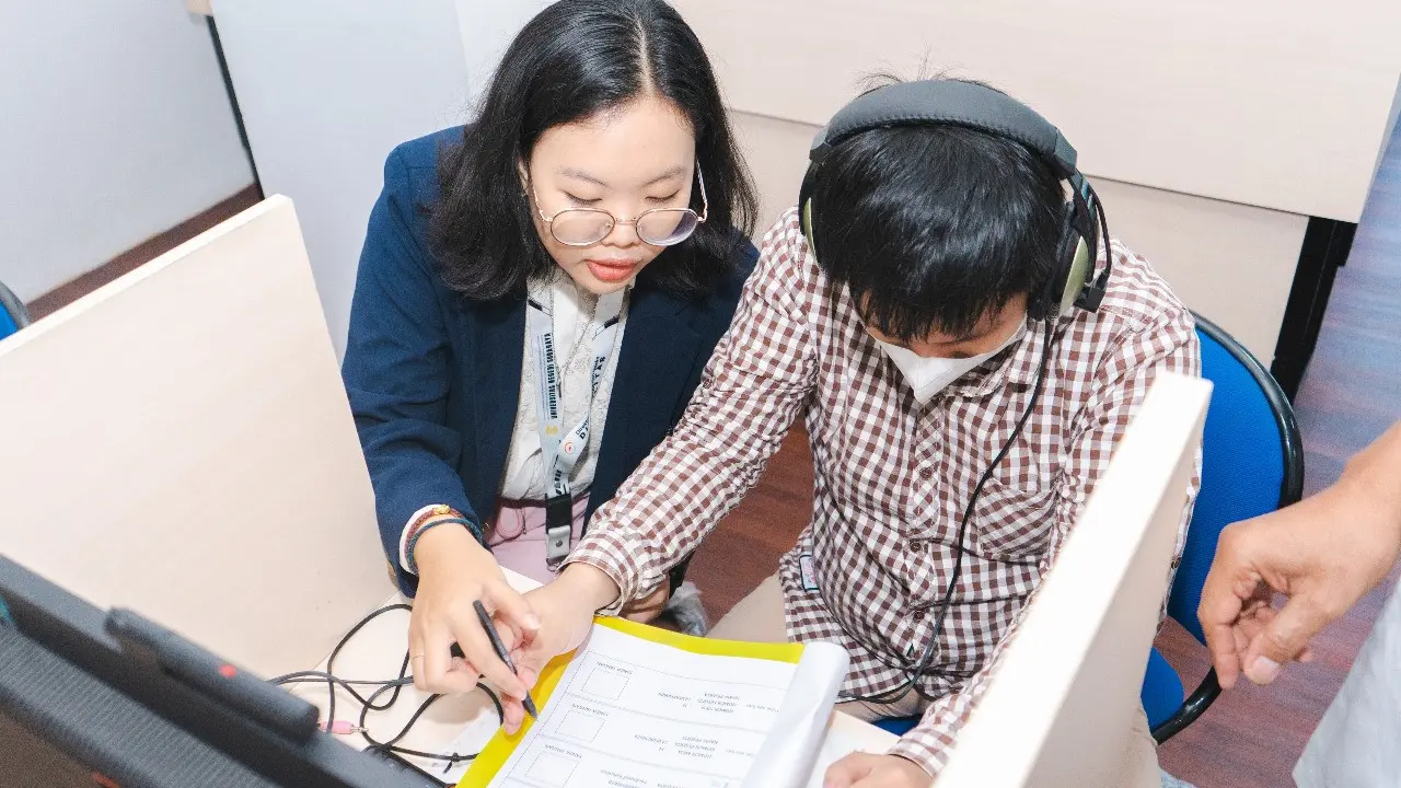 Disabilitas peserta UTBK mengerjakan soal dengan pendampingan. (Istimewa)