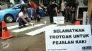 Para Aktivis Pejalan Kaki mengecat marka jalan  di kawasan Tosari, Jakarta, Jumat (11/12). Aksi tersebut di merupakan teguran untuk pemerintah agar serius menangani masalah kecelakaan. (Liputan6.com/Helmi Afandi)