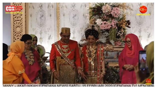 Danny pun mengenakan pakaian serasi dengan Raiyah, ia melengkapi penampilannya dengan songkok berwarna emas.