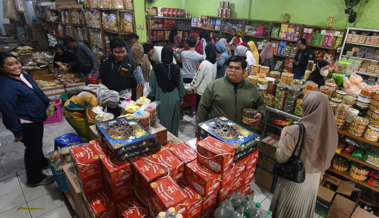 Pembeli melakukan pembayaran kue kering pada toko kue yang berada di sekitar Pabrik Kue Khong Guan di Ciracas, Jakarta Timur, Rabu (26/3/2025). (merdeka.com/Arie Basuki)