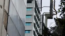 Petugas melepas plat aluminium pelapis dinding gedung Sekretariat Jenderal DPR RI yang roboh ditiup angin kencang di Kompleks Parlemen, Jakarta, Jumat (24/04/2015). Robohnya dinding karena usia gedung yang sudah lama. (Liputan6.com/Andrian M Tunay)