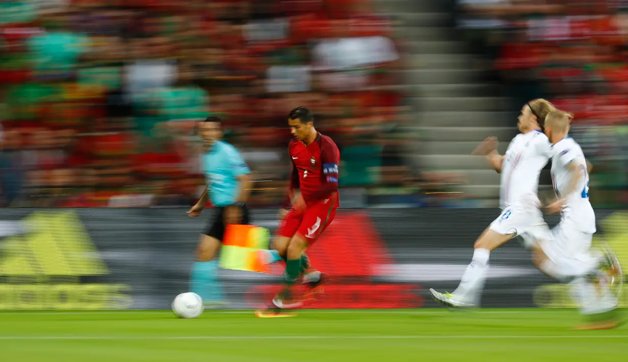 Penyerang Portugal, Cristiano Ronaldo berusaha membawa bola dari kejaran dua pemain Islandia pada laga Grup F Piala Eropa di Stade Geoffroy-Guichard, Prancis, Selasa (14/6). Islandia berhasil tahan imbang Portugal 1-1. (REUTERS/Kai Pfaffenbach)