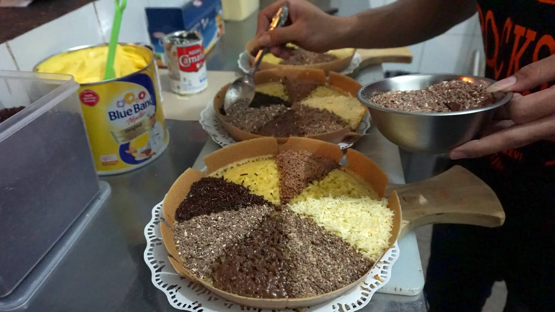 Juru masak Markobar sedang menaburkan topping coklat di permukaan martabak delapan rasa yang akan menjadi menu hidangan resepsi pernikahan Kahiyang-Bobby.(Liputan6.com/Fajar Abrori)