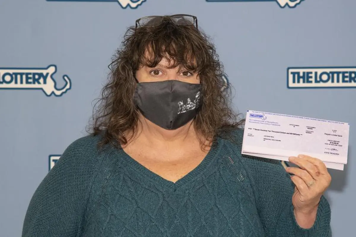 Lea Rose Fiega memamerkan tiket lotere yang dimenangkannya, di markas Massachusetts Lottery Commission,di Boston, Amerika Serikat. (Photo credit: Massachusetts Lottery Commission Photo via AP)