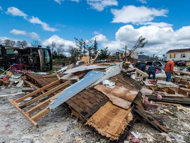 Warga dibantu relawan membersihkan puing-puing rumah mereka usai diterjang badai di Elon, Virginia (16/4). Badai disertai hujan lebat dan angin kencang melanda Virginia. (Jay Westcott/The News & Advance via AP)