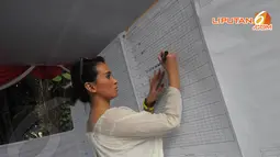 Ayushita menulis pada papan penghitungan suara dari kertas suara yang dibacakan juri lainnya (Liputan6.com/Herman Zakharia)