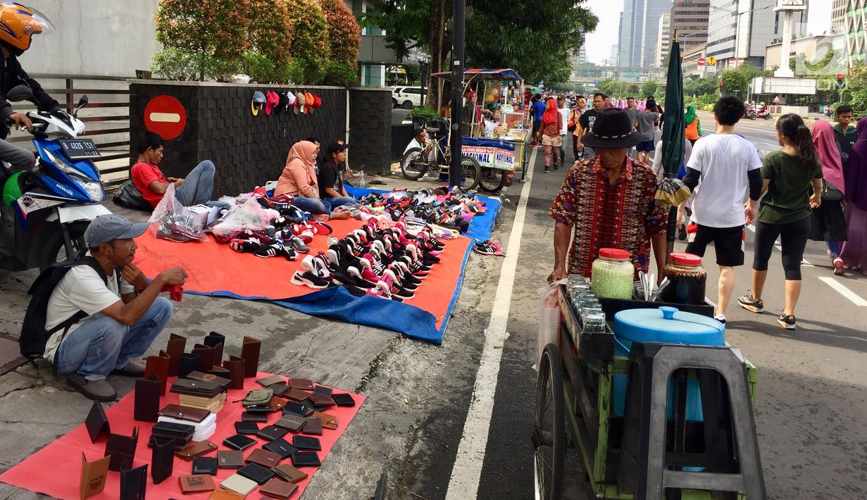 Sejumlah pedagang kaki lima (PKL) menggelar dagangannya di bahu jalan saat car free day (CFD) di Jakarta, Minggu (11/2). (Liputan6.com/Immanuel Antonius)