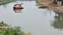 Perahu getek melintasi aliran Kanal Banjir Barat yang tengah dipenuhi sampah, Jakarta, Senin (22/10). Sampah yang memenuhi aliran kanal pencegah banjir tersebut didominasi plastik dan limbah rumah tangga. (Merdeka.com/Iqbal Nugroho)
