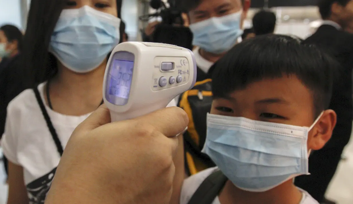 Seorang anak laki-laki menjalani pemeriksaan suhu badan saat tiba di Bandara Internasional Bangkok Suvarnabhumi, Thailand, Minggu (21/6/2015). WHO mencatat ada 1.334 kasus MERS di 26 negara. (REUTERS/Kerek Wongsa)